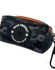 Dog Poop Bag Holder in black and gray camo with orange zipper and Wag Trendz logo on a white background