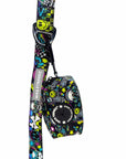 Dog Poop Bag Holder - Skull Society with multicolored graphics in yellow, blue, purple with black background - attached to the matching leash - against solid white background - Wag Trendz