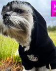 Hooded Sweatshirt For Dogs - Shih Tzu mix wearing "Good Life" hooded sweatshirt in black with hood on - front view - with white finger peace sign emoji on front - sitting outdoors in a grassy field - Wag Trendz