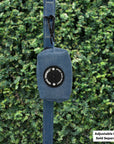 Dog Poop Bag Holder - Downtown Denim - hanging on a denim dog leash with the black rubber logo dispenser on front - against a greenery background - Wag Trendz
