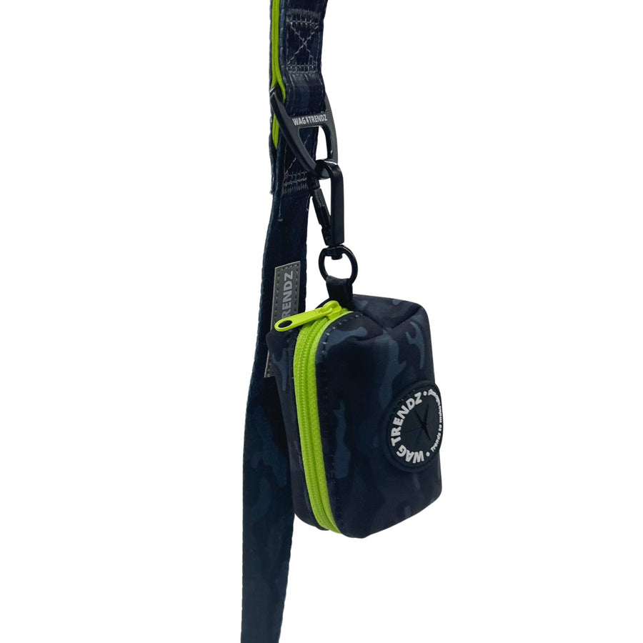 Dog Poo Bag Holder - black and gray camo design with a hi-vis zipper and black rubber logo dispenser on front - hanging from a matching leash against a solid white background - Wag Trendz