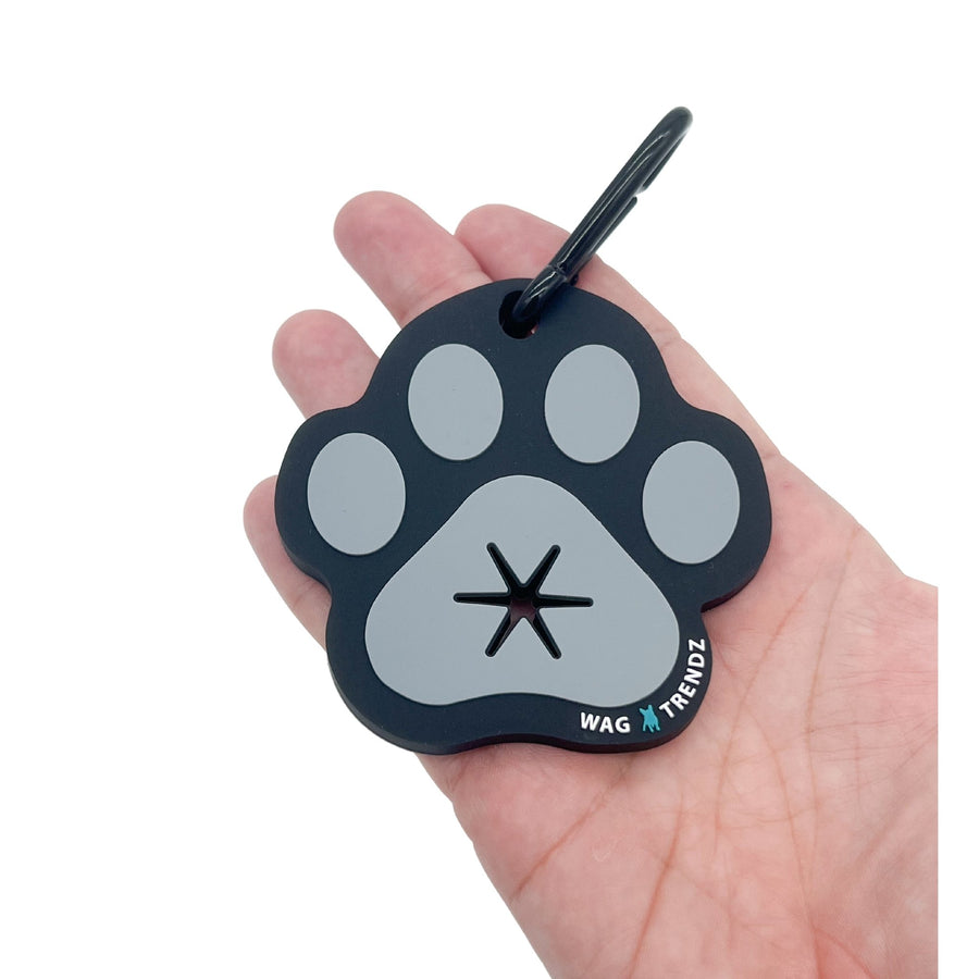 Poop Buddy - black and gray resin dog paw - laying in the palm of a hand - against solid white background - Wag Trendz