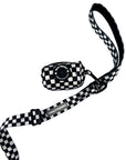 Adjustable dog leash in black and white checkered pattern with matching checkered poop bag holder