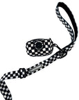 Adjustable dog leash in black and white checkered pattern with matching checkered poop bag holder