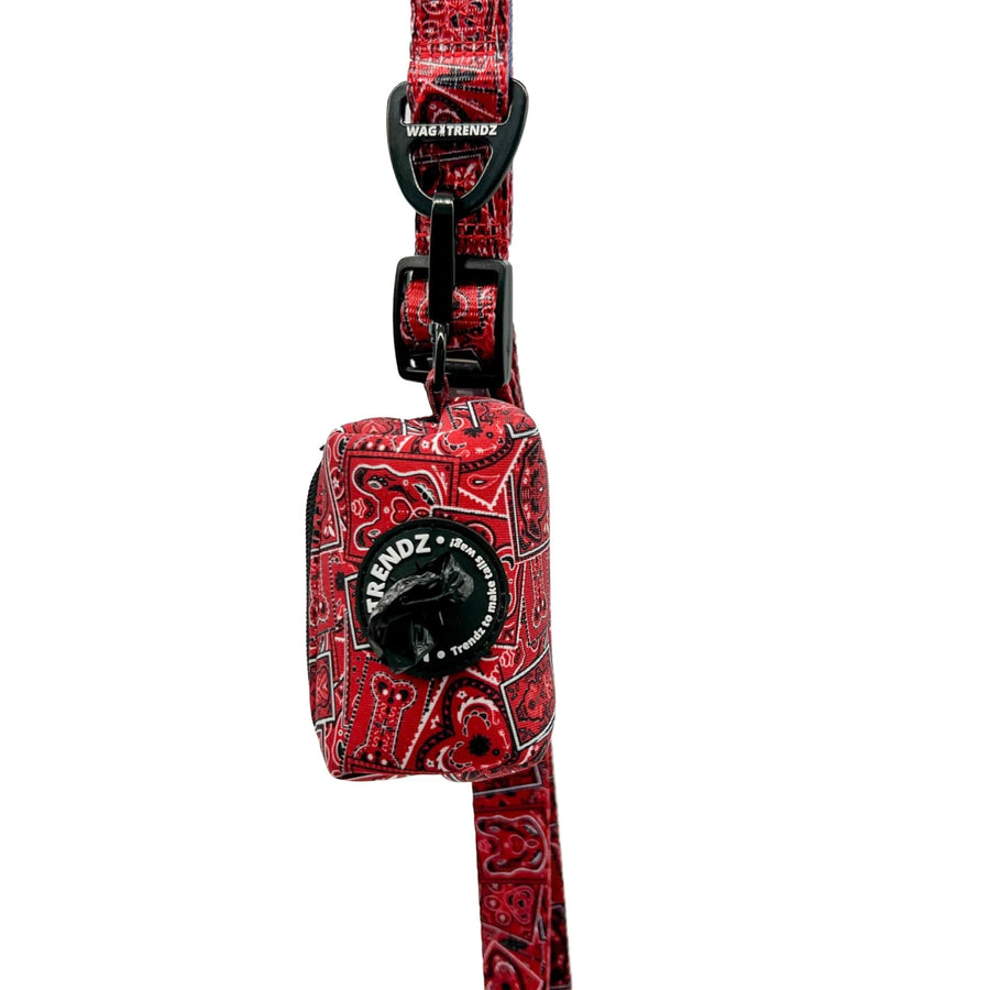Dog Poo Bag Holder - Bandana Boujee - Red with black zipper and black rubber logo dispenser on front hanging on matching dog leash - against a solid white background - Wag Trendz
